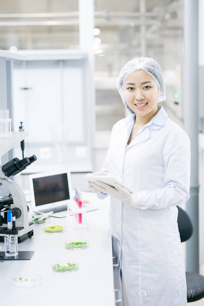 亚洲女科学家肖像在医学实验室研究中微笑着开心的看着相机照片-正版