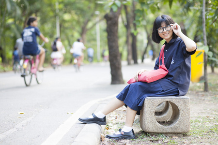 女孩戴着眼镜坐在走廊的长椅上