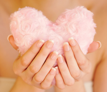 在女性手中的毛皮粉红色心图片