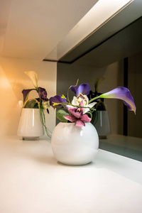 白色花瓶白色架子上的美丽紫色花朵室内装饰