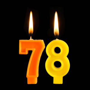 生日燃烧蜡烛的形式78七十八为蛋糕隔离黑色背景