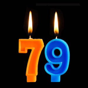 生日燃烧蜡烛的形式79七十九为蛋糕隔离黑色背景