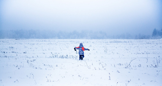 在一个下雪的公园里逃跑的小女孩