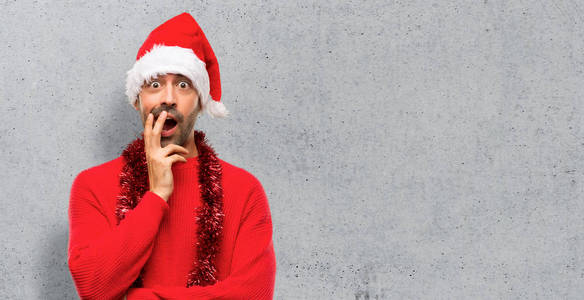 穿着红色衣服庆祝圣诞节假期的男子在观看质感背景时感到惊讶和震惊