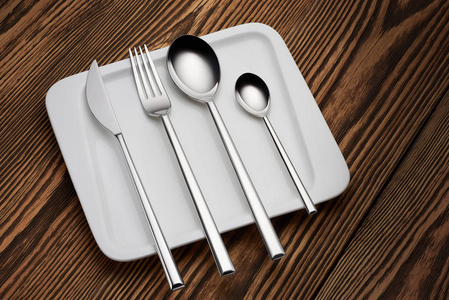 勺子刀叉在盘子和旧的木桌上。餐厅菜单概念