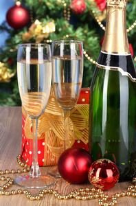 戴着眼镜，圣诞球圣诞树背景上木制的桌子上香槟瓶