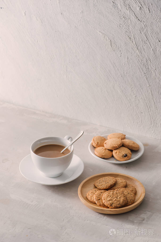 杯咖啡与牛奶或卡布奇诺与饼干在轻石背景。用或可可饮料喝牛奶。咖啡打破概念