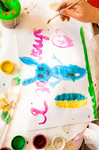 拍摄的小女孩在画蓝色兔子在画布上