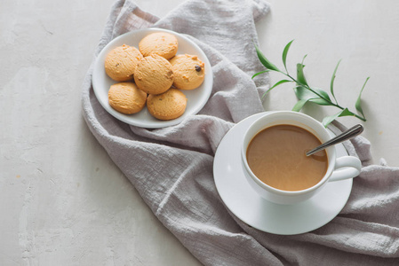 特写咖啡与牛奶在白杯和美味的饼干。轻石背景拍摄