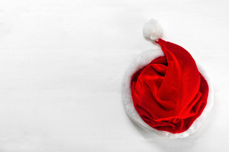 明亮的红色圣诞老人帽子在木质背景。顶部视图平面放置组对象