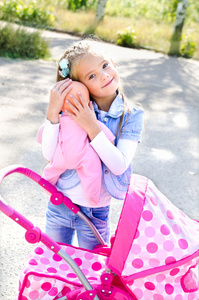 可爱微笑的小女孩玩她的玩具马车