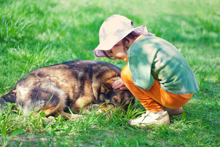 小女孩拍了拍一只大狗在草地上