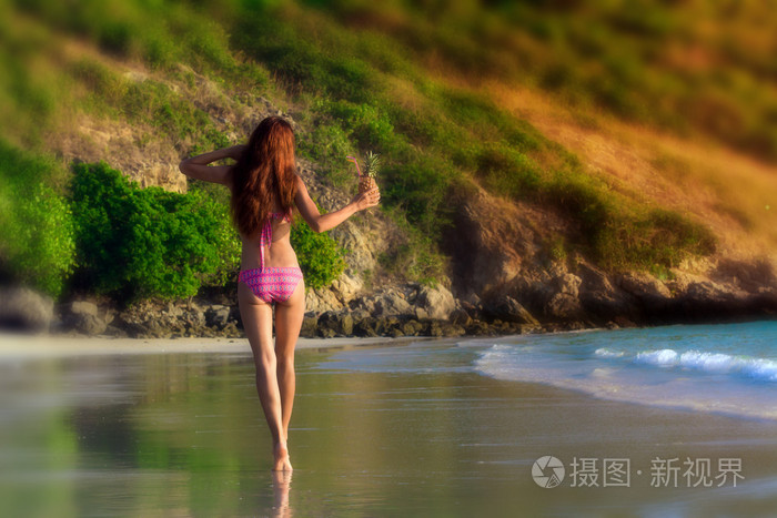 年轻女人醒来沿着沙滩