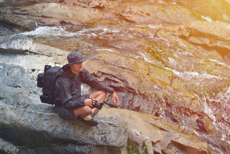 自然职业摄影师在瀑布附近休息
