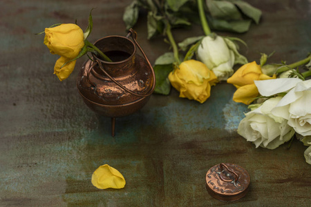 黄色玫瑰在一个青铜花瓶, 在一个彩绘的桌子上, 雨后