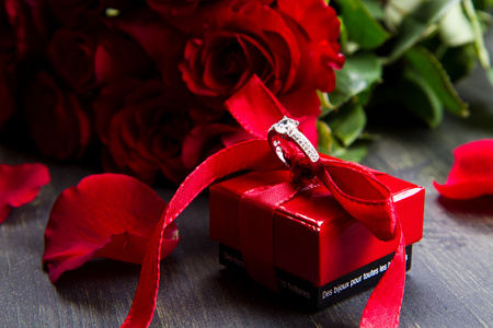 情人节那天红玫瑰和礼品盒木制背景上