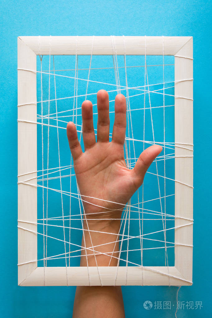 心理健康概念女人的手试图打破蓝色背景上的枷锁