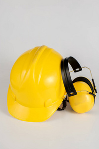 在白色桌子上的头盔和听觉保护。建筑工人的安全和卫生用品。白色背景