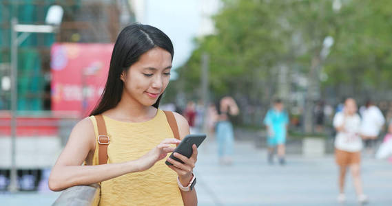 城市的旅行妇女使用智能手机