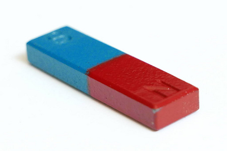蓝色和红色长方形磁铁与南北极隔绝在白色背景上