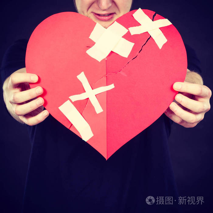 坏的关系分手悲伤的情感概念很悲哀的年轻人抱着破碎的心用纸做的