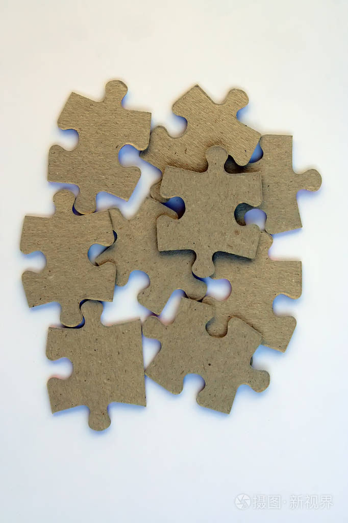 堆拼图碎片在白色背景上的拼图片断棕色硬纸拼图片