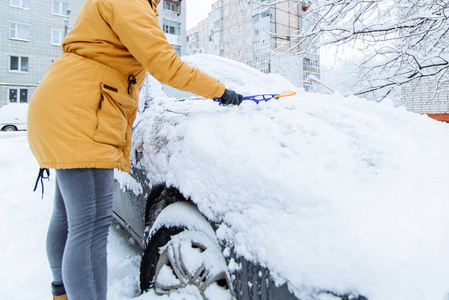 雪灾过后, 妇女在清洗她的雪车。冬季时间