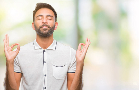 成年西班牙裔男子在孤立的背景下放松和微笑闭上眼睛做冥想手势用手指。瑜伽理念