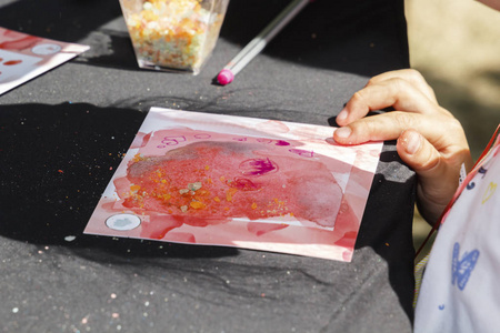 在阳光明媚的日子里, 在街上的创意工场里, 孩子用油漆作画。复制空间