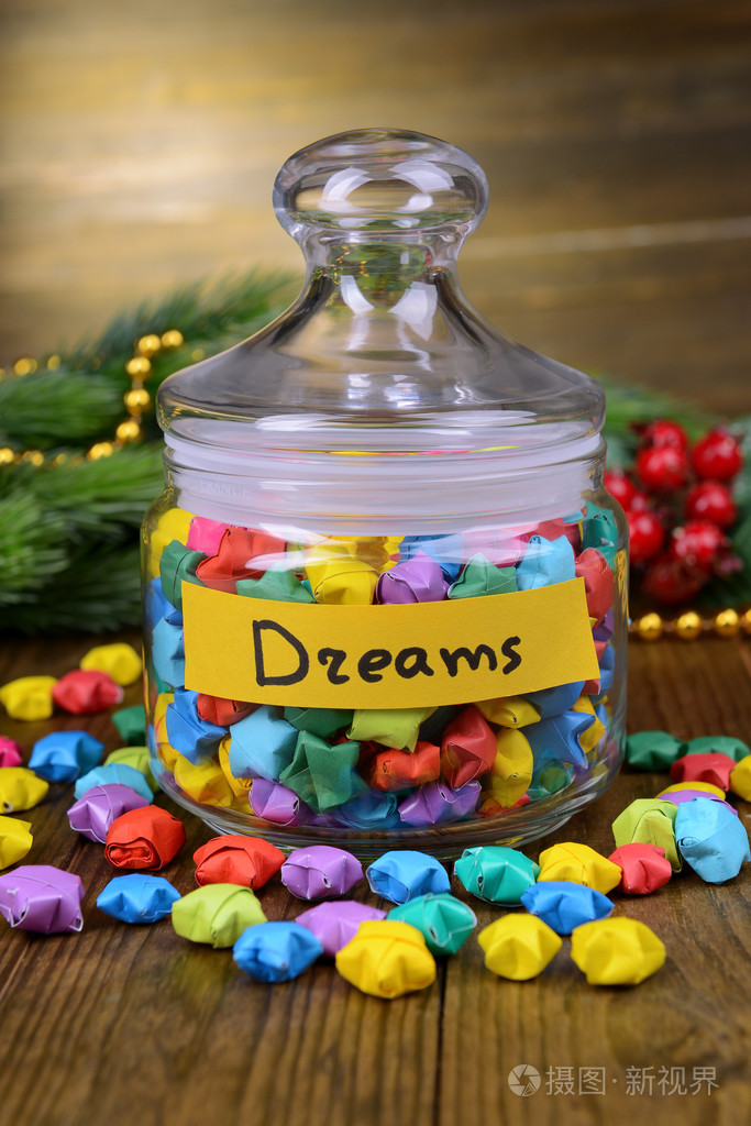 纸星星与木制背景上的桌子上的瓶子里的梦想