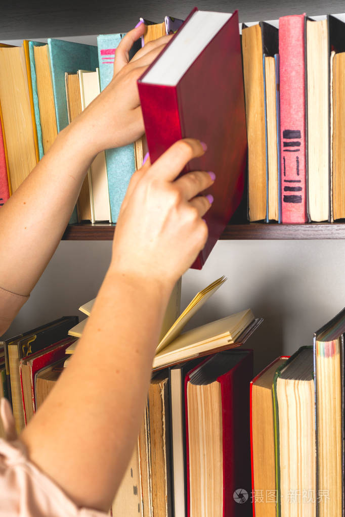 照片 穿浅色衣服的年轻女孩正在看书.女性手中握着一本书.jpg