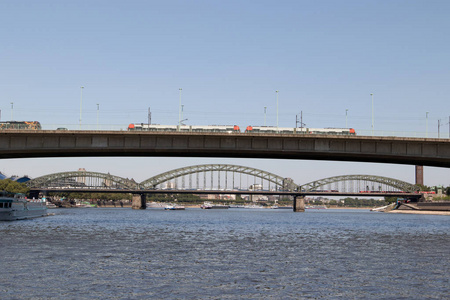 火车通过 severins 桥梁和 deutzer 桥梁在背景在科隆德国在小船旅行期间被拍照在河莱茵河与广角透镜