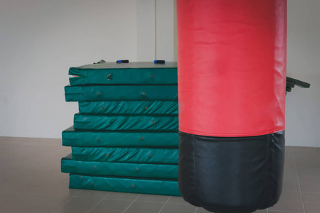 红色和黑色的沙袋打和冲压在拳击馆。体育健身生活方式概念
