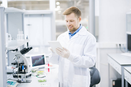 科学家穿着腰部向上的微笑年轻的科学家穿着实验室大衣工作研究使用