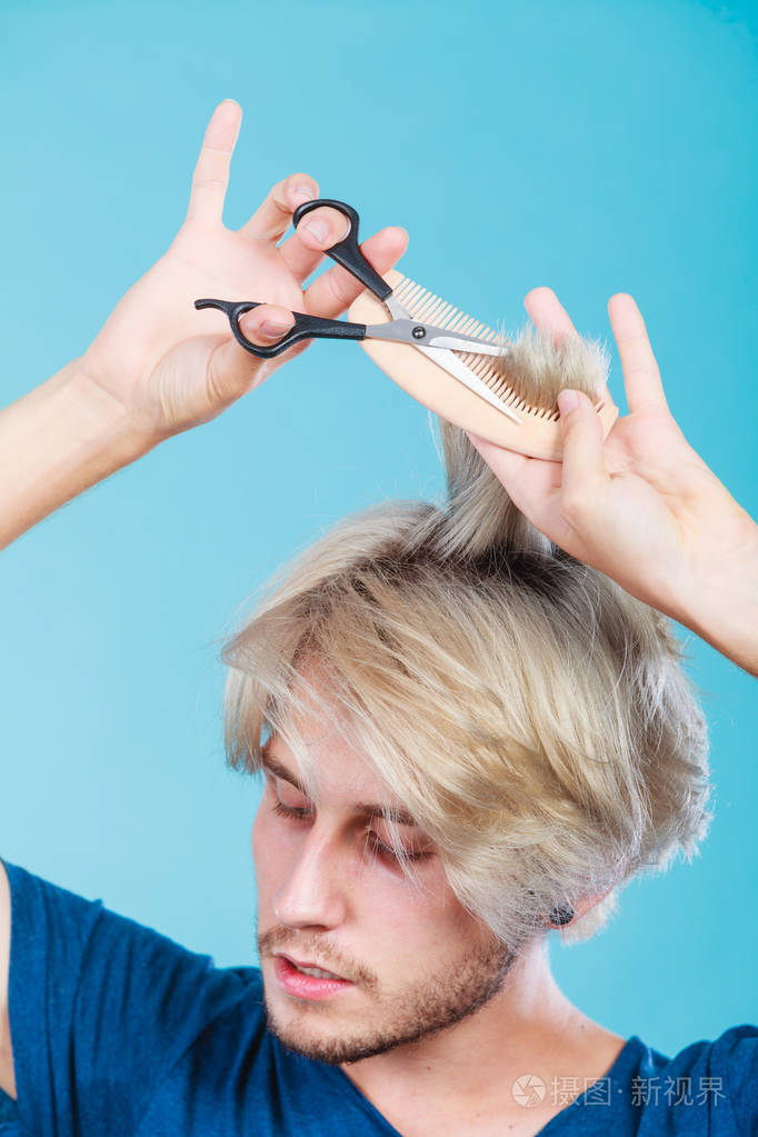 风格和时尚年轻时尚男性发型师理发师的外观改变的新主意用剪刀和木梳