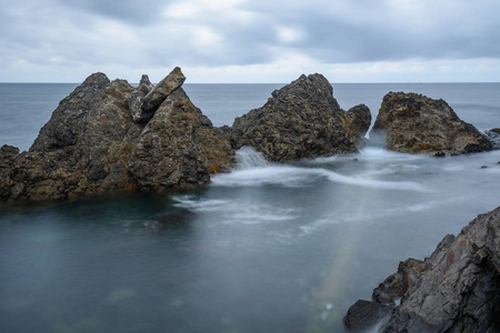 西班牙巴斯克国家多云的一天, 一组在大西洋沿岸的岩石被平静的海水包围着。