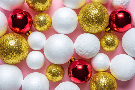 金色和白色闪光球装饰与红色圣诞小泡在粉红色的背景。新年最小的概念。特写