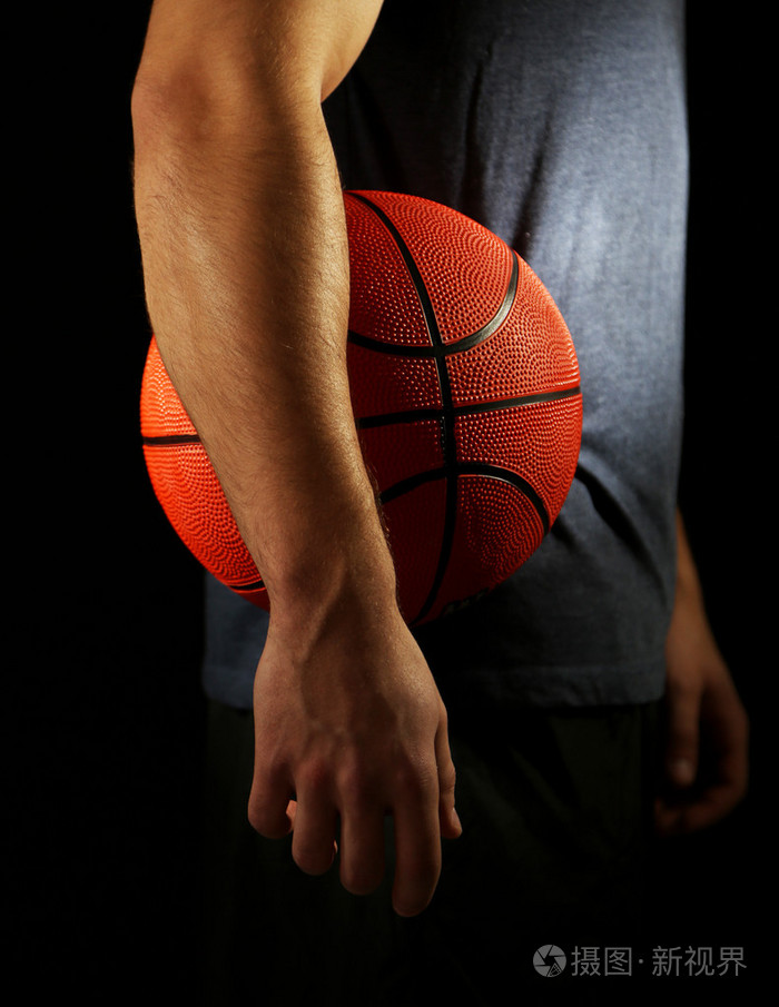 篮球运动员握球,在深色背景上照片-正版商用图片09h443-摄图新视界