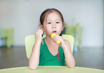 儿童女孩唱一首歌的塑料麦克风在儿童室小美女在录音室唱歌两个姐妹