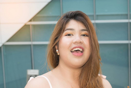 亚洲漂亮笑脸的画像胖女人摆在建筑的幸福前面