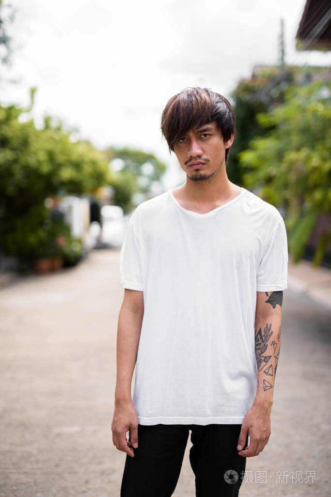 年轻的亚洲男子手纹身在街头户外