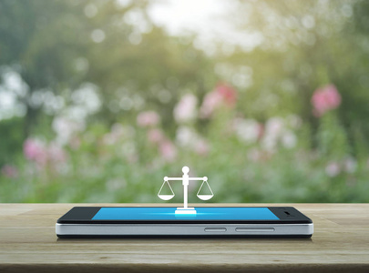 法律平面图标在现代智能手机屏幕上的木桌上模糊粉红色的花和树, 商业法律服务在线概念