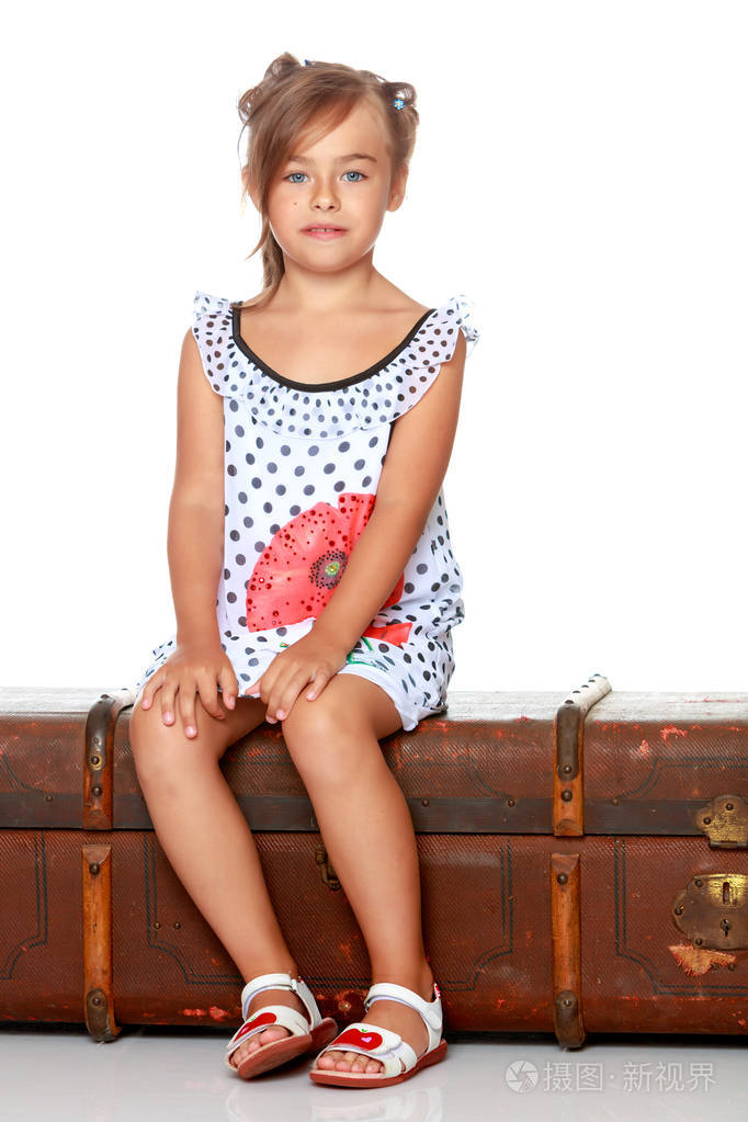 一个小女孩正坐在一个木制的盒子