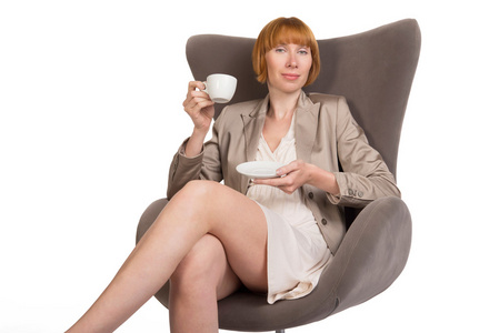 年轻的女士，坐在现代椅子上，用一杯咖啡厅风格