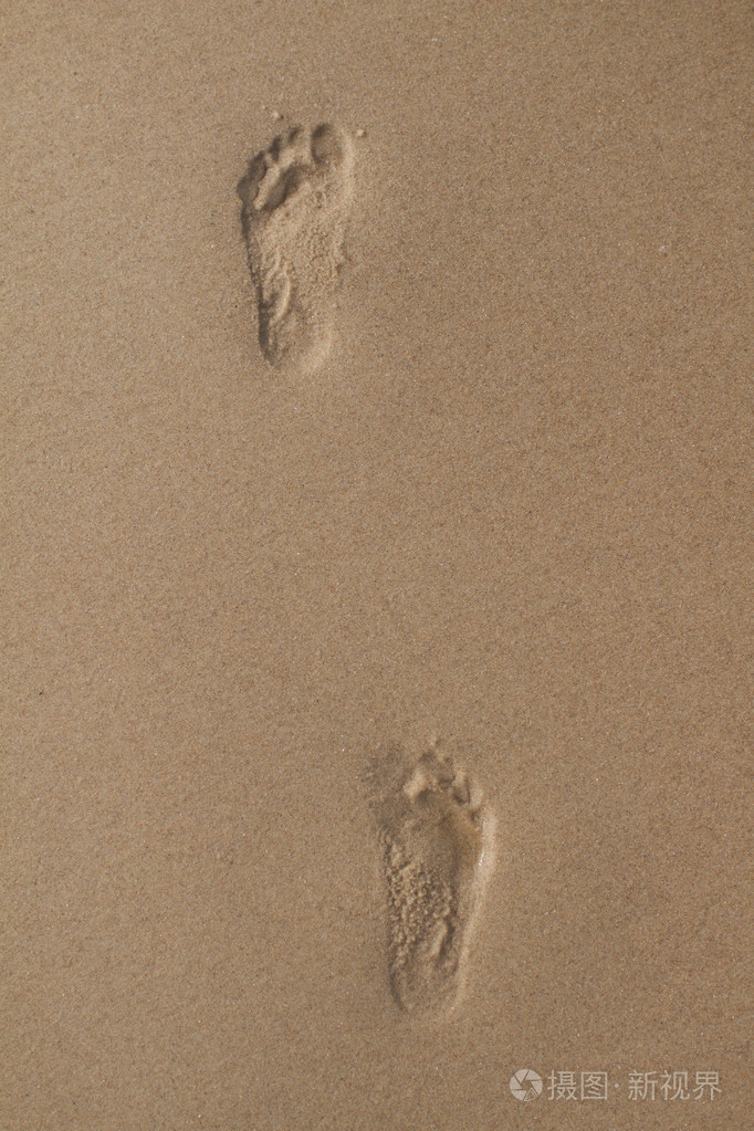两种人类足迹在潮湿的沙子