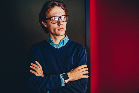 周到的商人与交叉的武器和 smartwatch 站在室内很酷的黑人青年思考