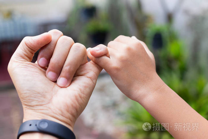 亲密的父子双手互相钩在一起的小手指许下诺言