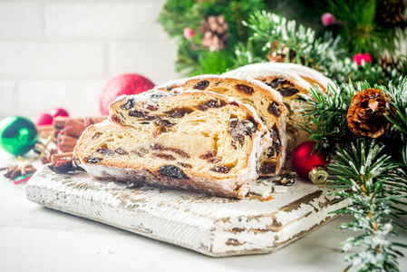 传统的欧洲圣诞糕点, 芳香的家庭烤肿胀, 与香料和干果。在木桌上切片, 有圣诞树树枝和装饰, 复制空间