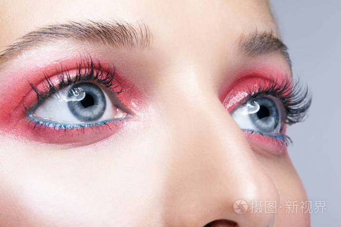 特写镜头的女性脸和粉红色烟熏眼睛美容化妆闪亮闪光白色皮肤的妇女