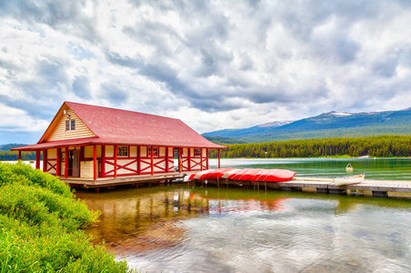 彩色独木舟位于加拿大艾伯塔省贾斯珀国家公园 Maligne 湖的船屋码头。湖以周围的山峰和三可见的冰川而闻名。